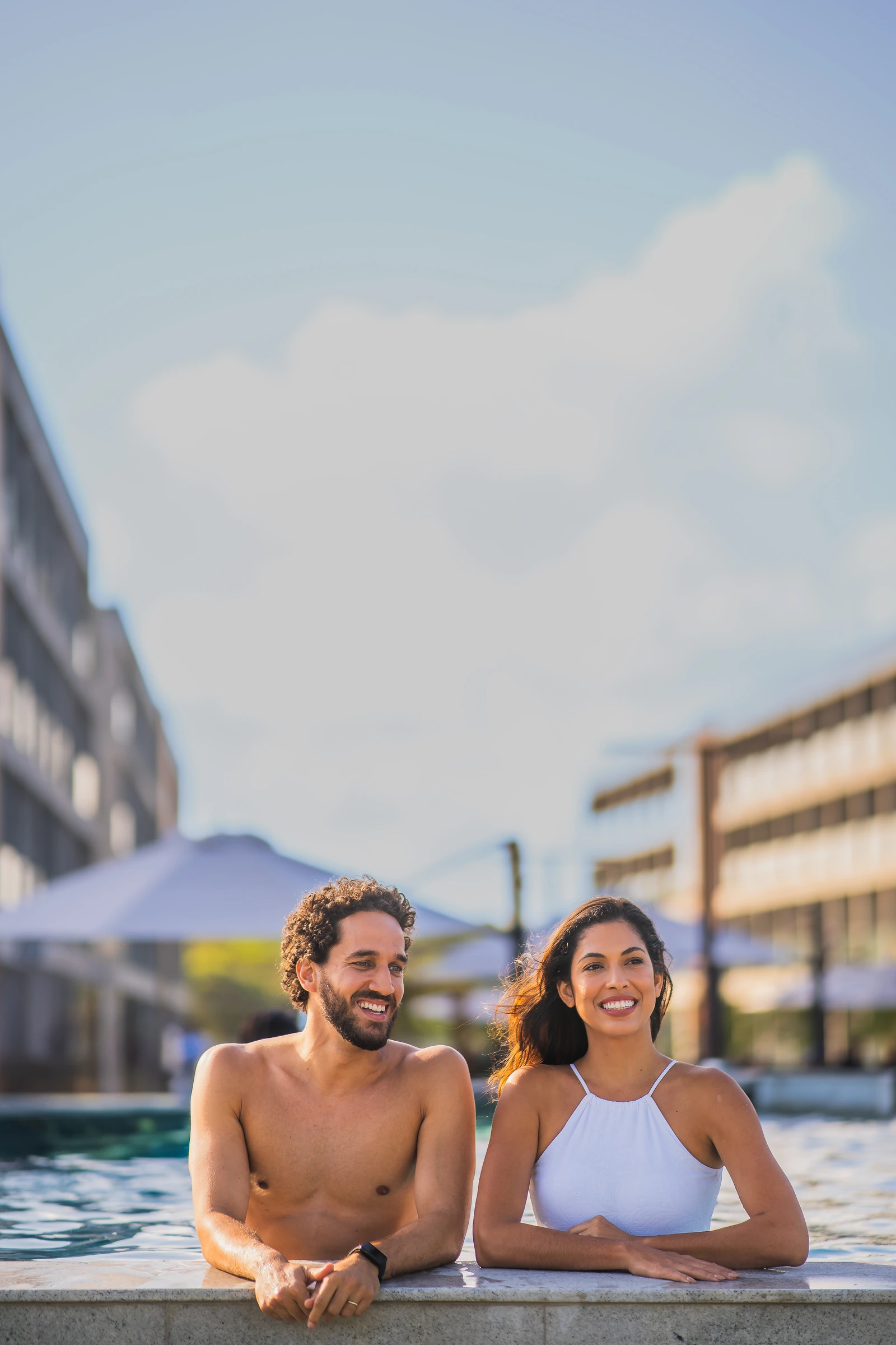 Casal aproveitando a piscina do Porto Alto