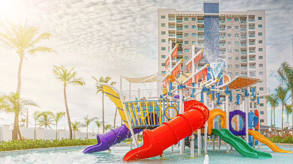 Parque aquático infantil em resort, com toboáguas coloridos, jatos d'água e temática de aventura.